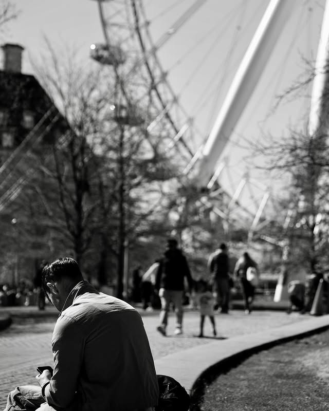 Person taking a moment for themselves in an urban park—a quiet pause in a busy world.